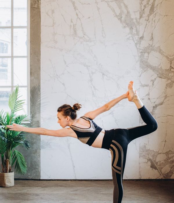 Woman performing a calm yoga pose in a dark, serene environment.